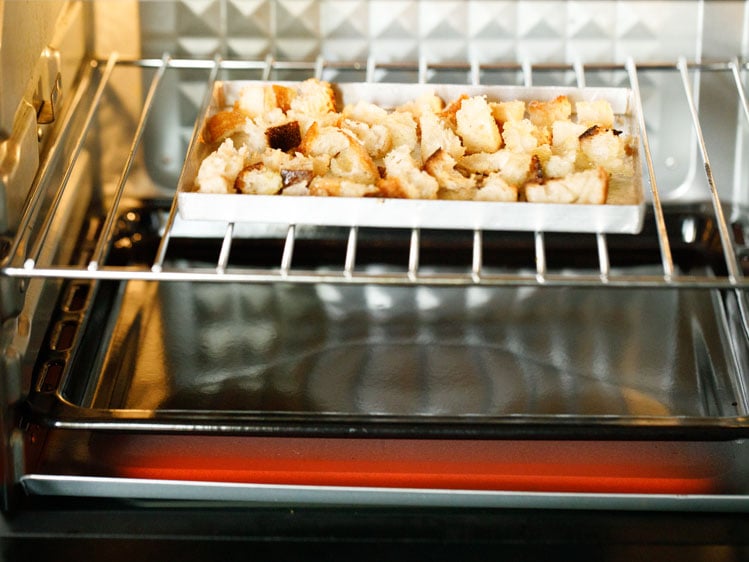 bread cubes being toasted in oven