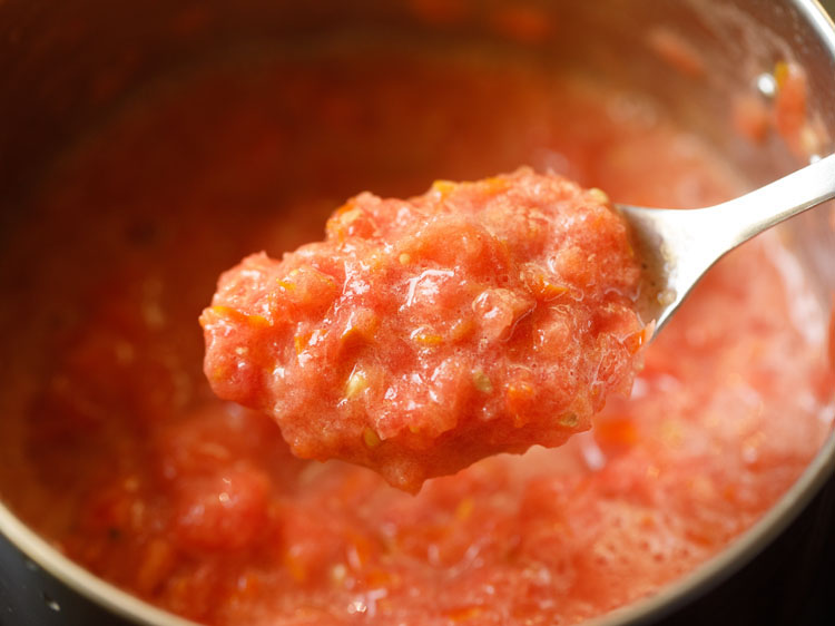 consistency of crushed tomatoes shown with a steel spoon