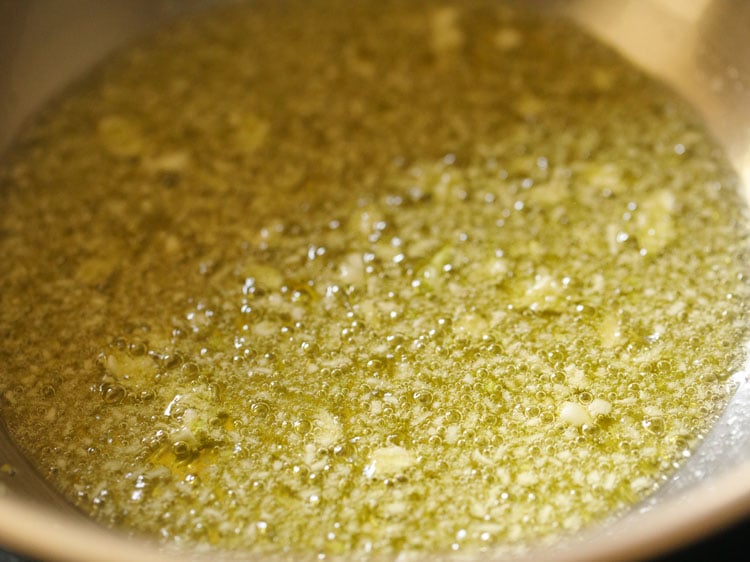 finely chopped garlic being fried in olive oil