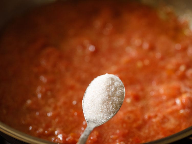 salt being added with a small steel spoon