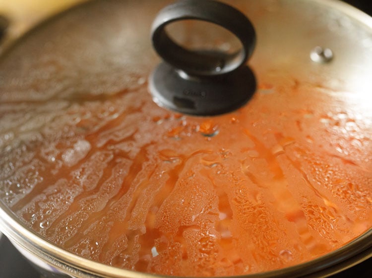 pizza sauce being cooked covered with a glass lid