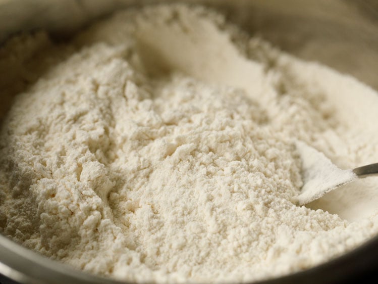 flour mix in a silver mixing bowl with a silver spoon