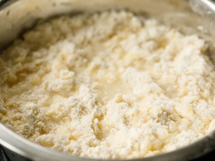 cold water added to butter and flour mix in a silver mixing bowl to make pie crust recipe