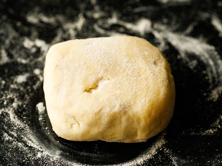 flour dusted surface with lightly floured piece of pie crust dough