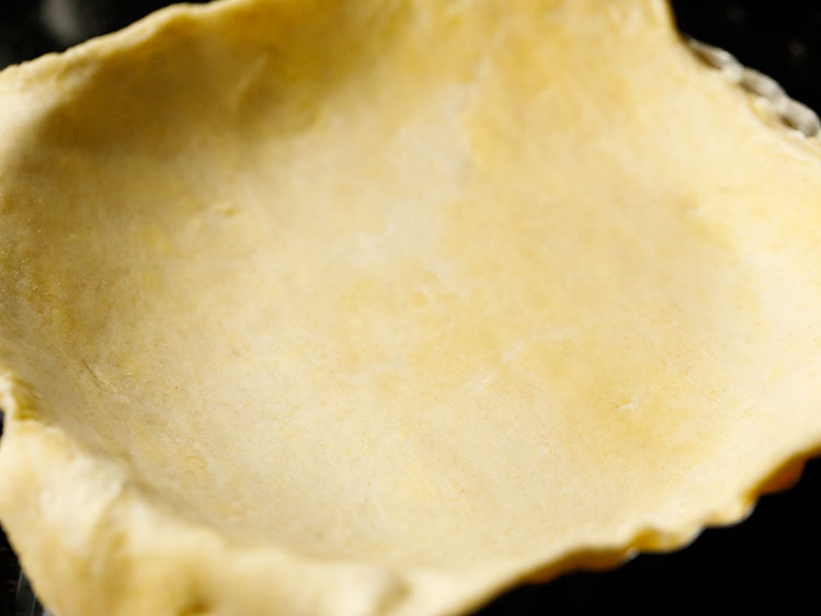 flaky pie crust recipe draped over a pie tin