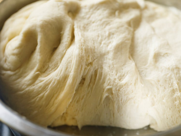 close up photo of the pizza dough showing stringy dough with air pockets
