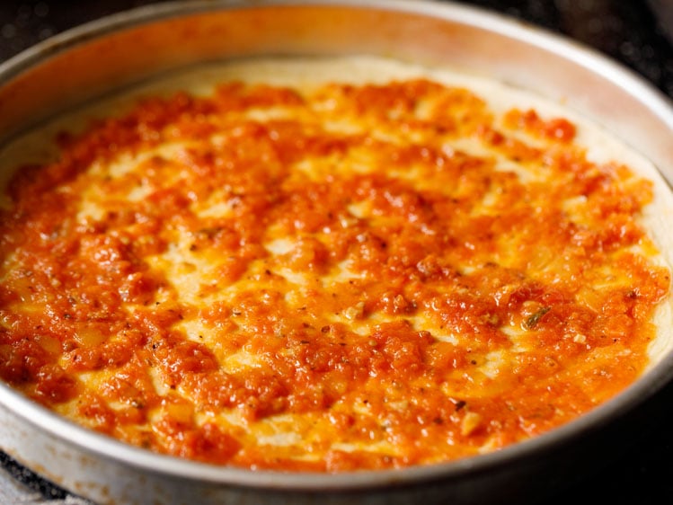 assembling-veg-pizza5 tomato sauce or pizza sauce spread on pizza dough