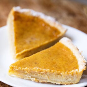two pumpkin pie slices on a white plate
