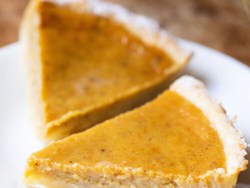 two pumpkin pie slices on a white plate