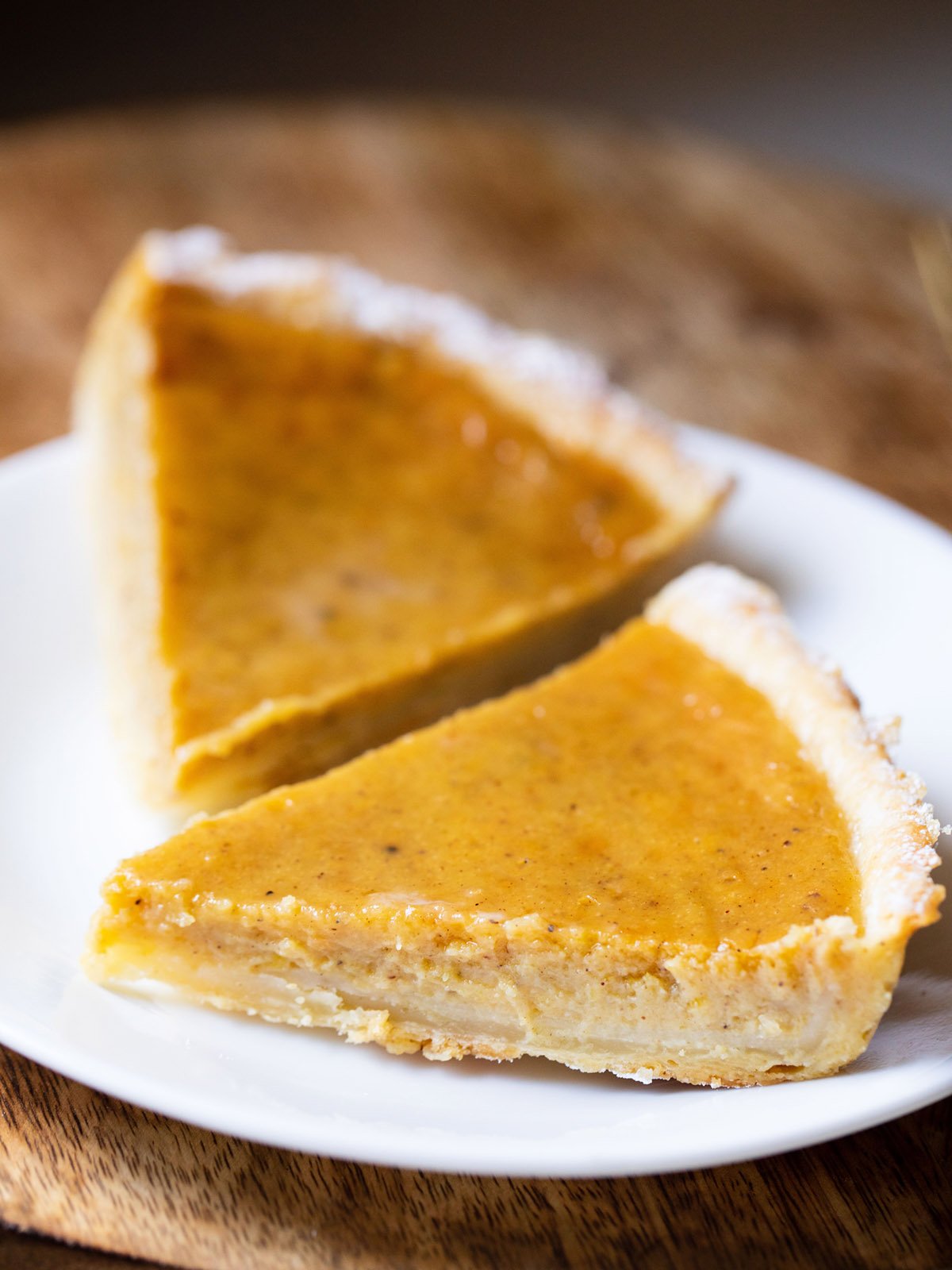 two pumpkin pie slices on a white plate