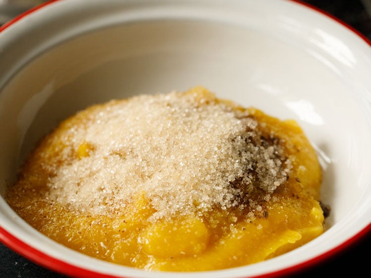 pumpkin purée in a white bowl with pumpkin pie spices and raw sugar
