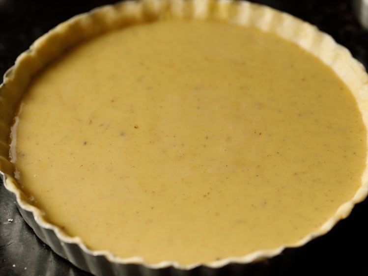 unbaked pumpkin pie in a silver fluted pie tin