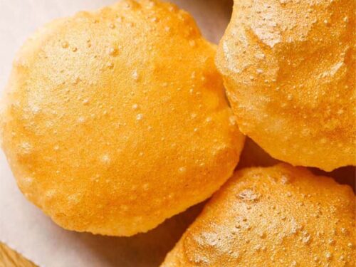 perfect golden puri placed on white parchment paper