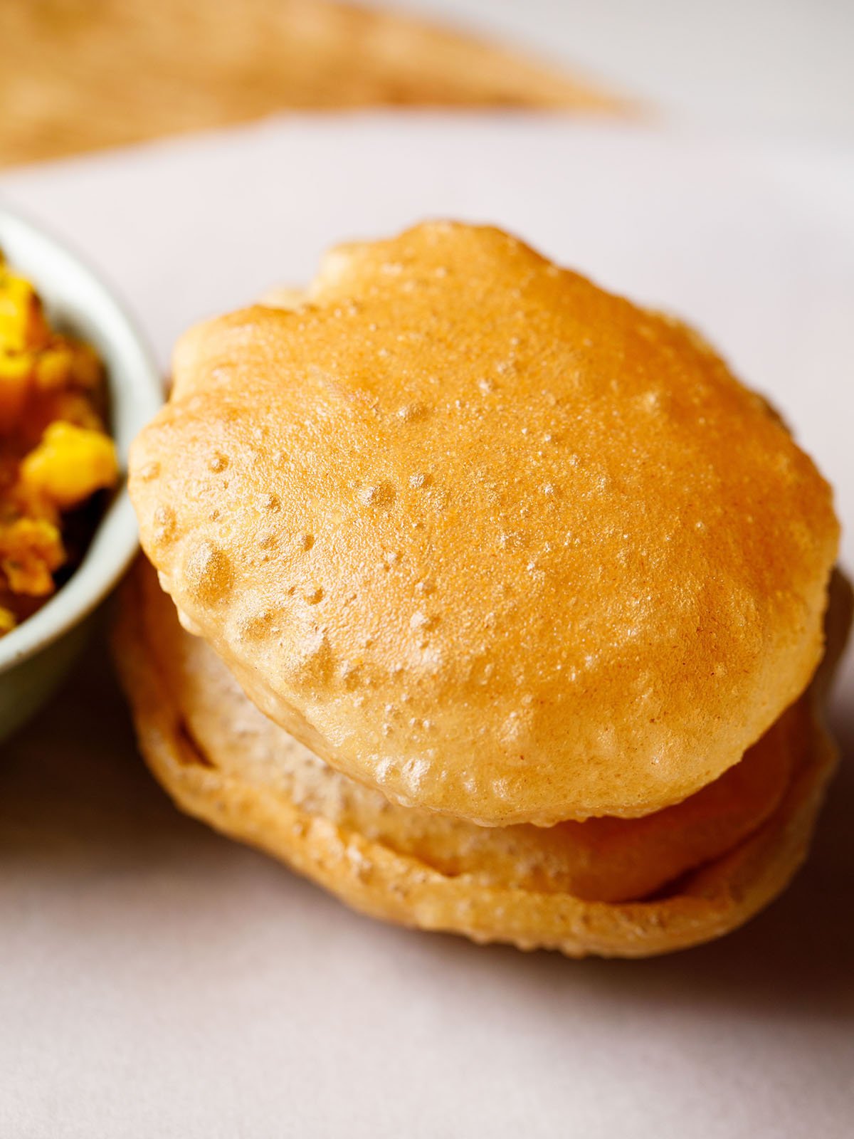 poori stacked on top of each other on a white parchment paper