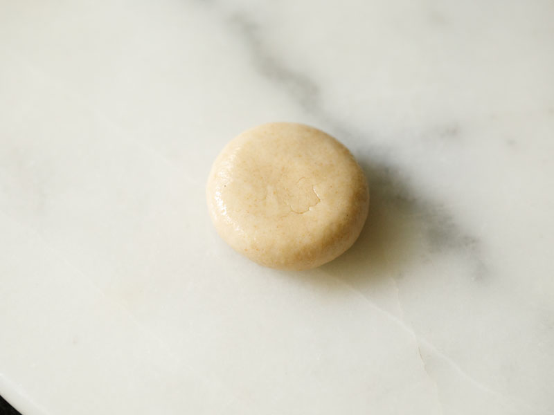 flattened dough ball with oil spread on it