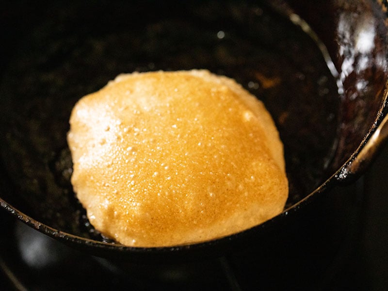 crisp golden homemade poori with the second side being fried in oil