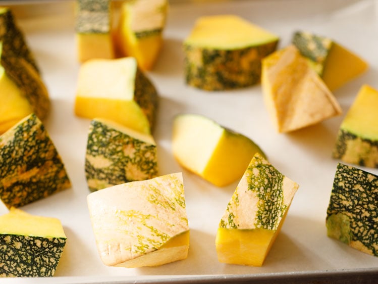 cubes of kabocha squash on a parchment lined baking sheet