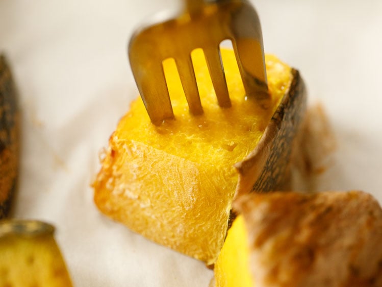 silver fork piercing a cube of roasted kabocha pumpkin