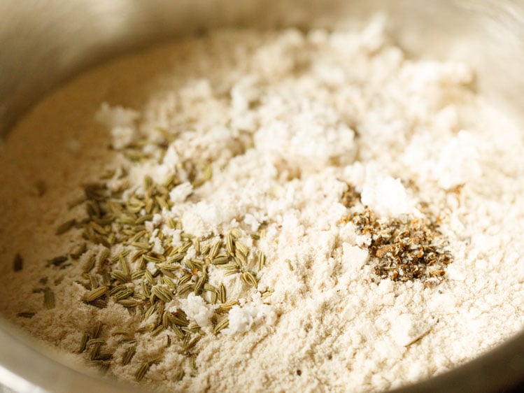 whole wheat flour, salt, fennel, dessicated coconut and cardamom in a mixing bowl