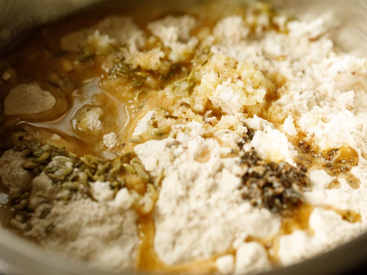 melted ghee added to dry ingredients for Thekua dough