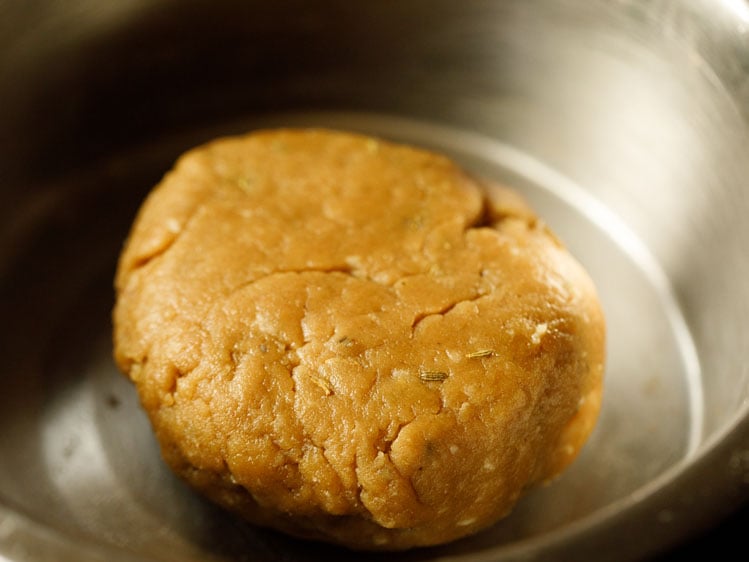 thekua dough after kneading into a shiny and relatively smooth dough ball in a silver mixing bowl