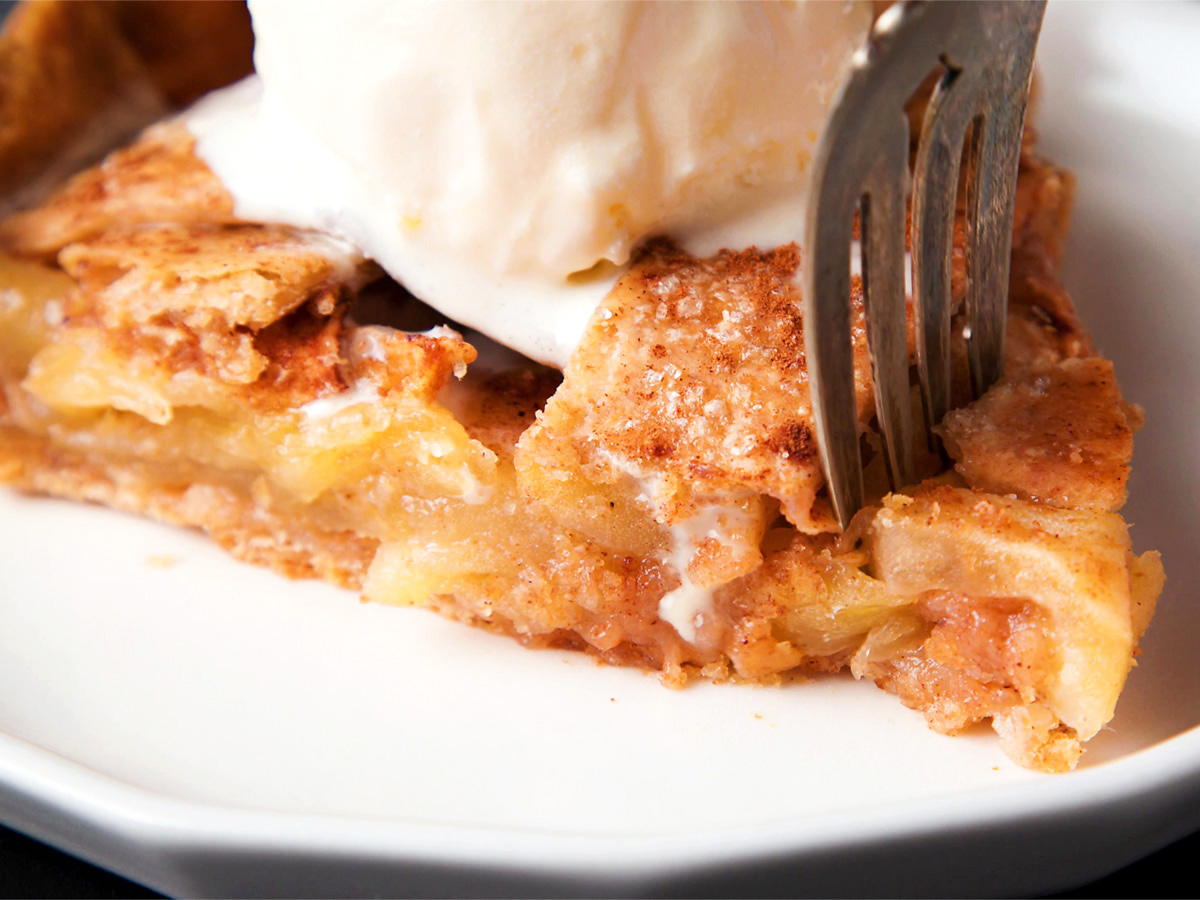 apple pie wedge being cut with a fork