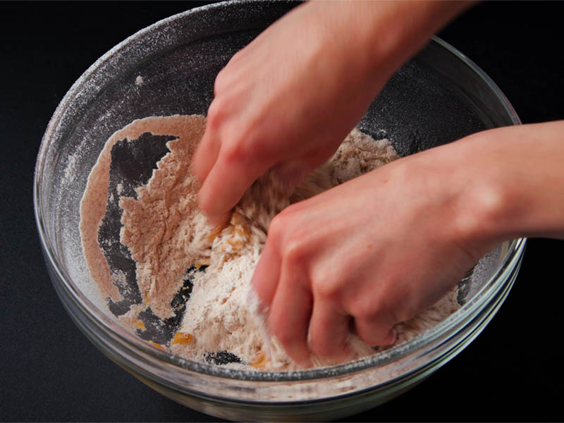 oil being mixed in flour with fingertips