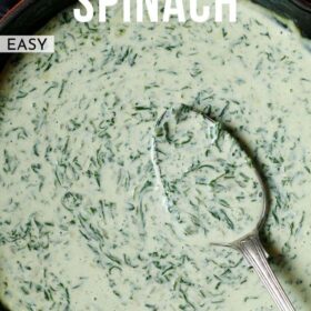 creamed spinach in a skillet with a brass spoon inside