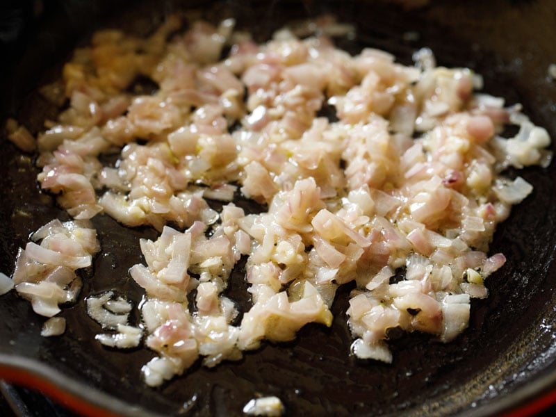 sautéed onions and garlic in a red enameled cast iron skillet