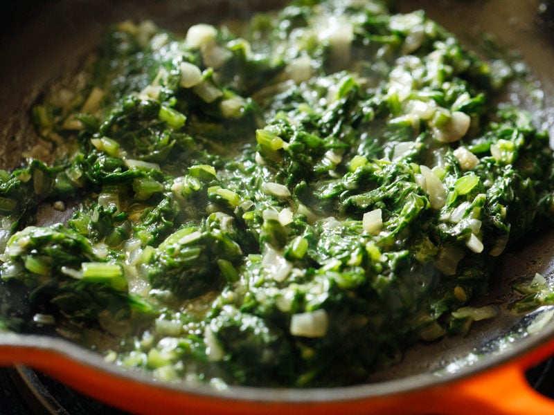 spinach mixture after cooking the flour down. the leaves are entirely wilted and the liquid has evaporated
