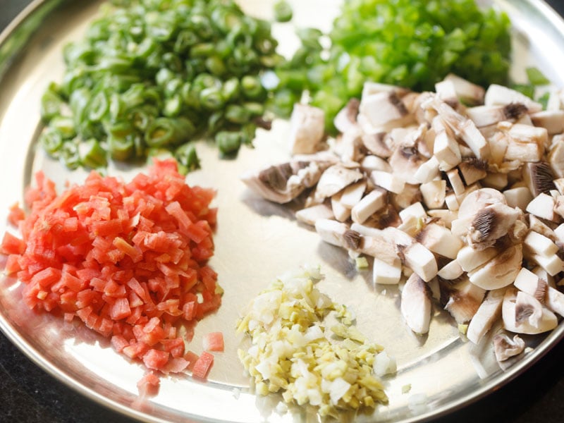 chopped mushrooms, beans, peppers, ginger, garlic on a steel plate for veg fried rice