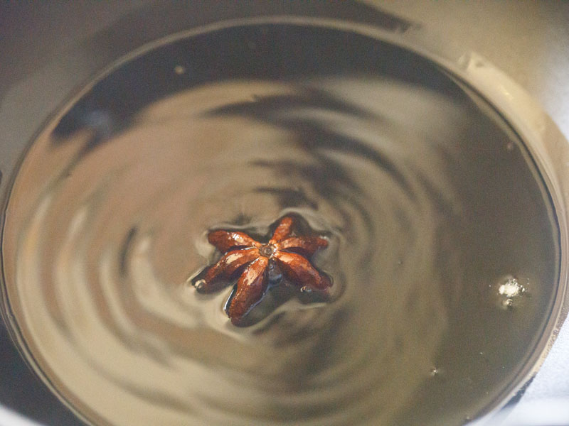 star anise being fried in shimmering oil