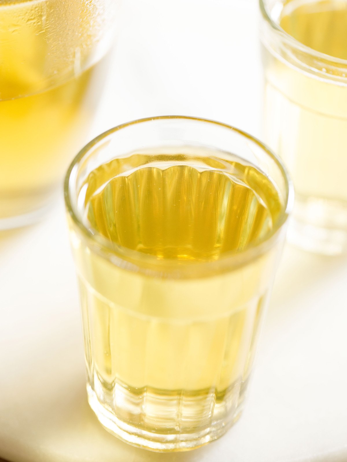 green tea in a transparent glass on a white marble board