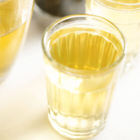 green tea in a transparent glass on a white marble board