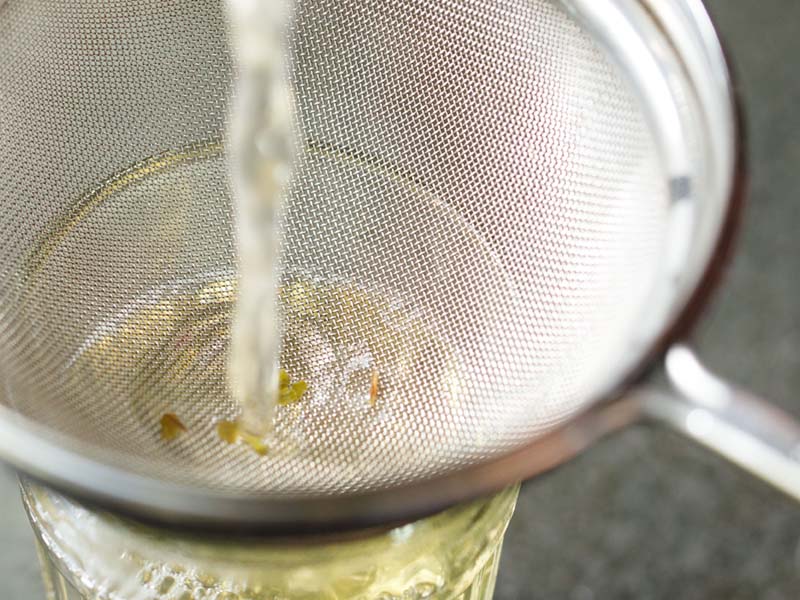 straining green tea leaves