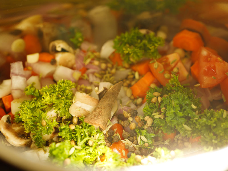 veggies, herbs and spices in the steel insert of the instant pot