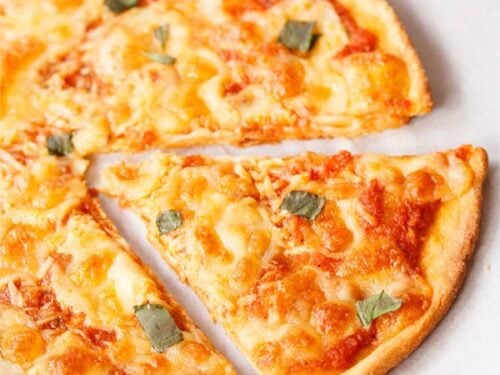 close up of margherita pizza wedge on butter paper
