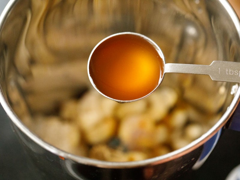 tablespoon of apple cider vinegar above the blender filled with eggless mayonnaise ingredients