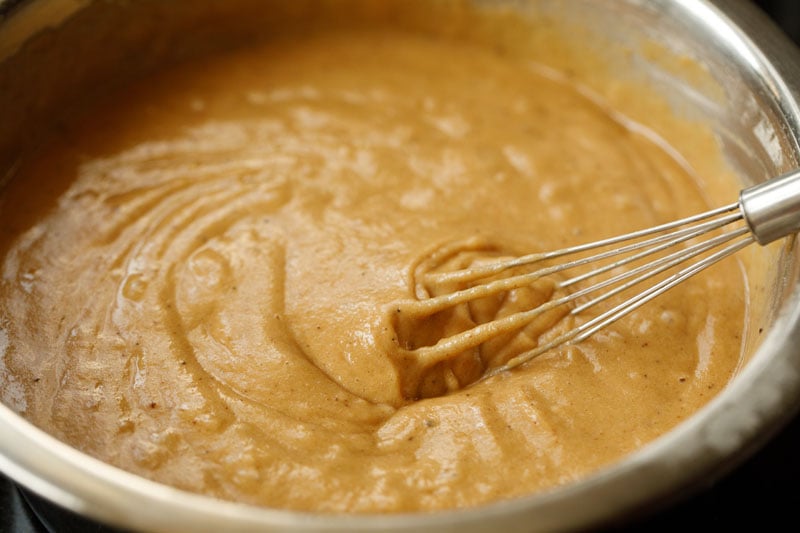 whisk mixing apple puree mixture with dry ingredients and formed the apple cake batter