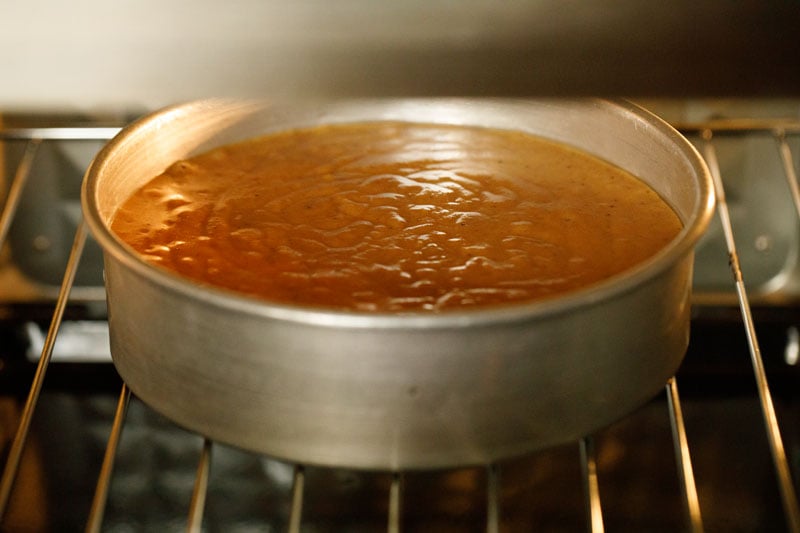 apple cake in baking dish inside a lit oven