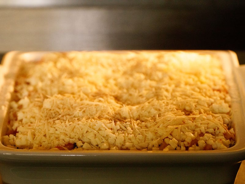 baked ziti casserole in a white casserole dish after just being put into the oven