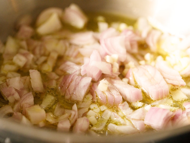 onions and garlic sautéing in a pan with oil