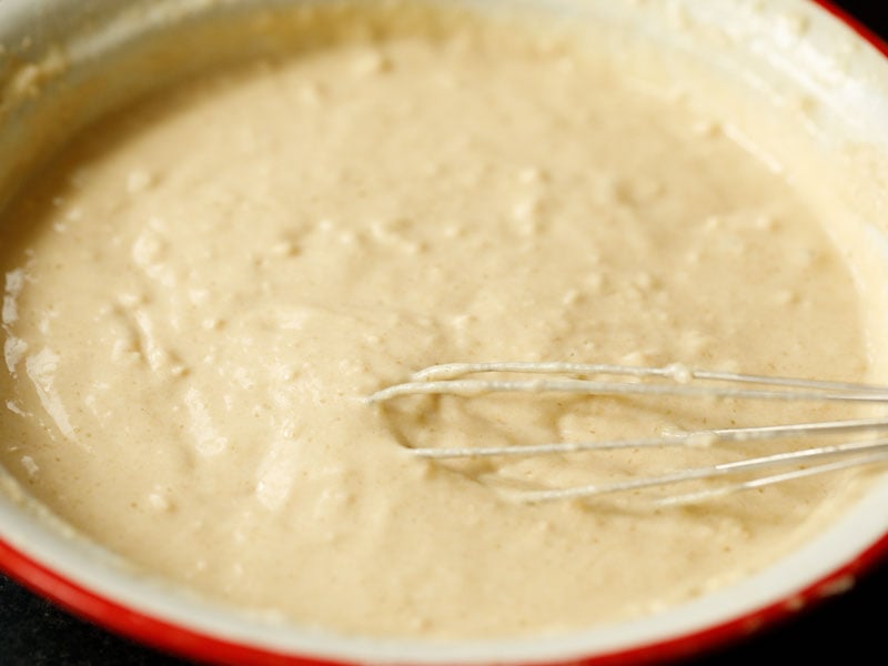 vegan pancake batter whisked together in a red and white mixing bowl