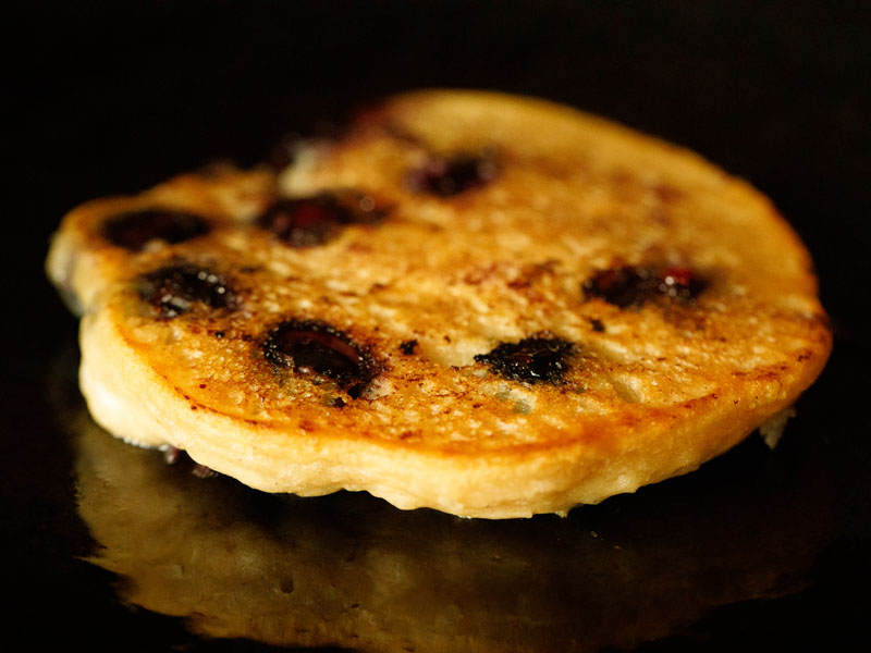 homemade blueberry pancake after flipping to cook on second side