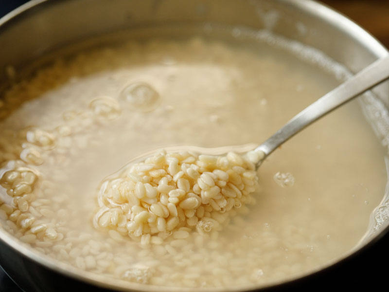 soaked lentils being shown with a silver spoon