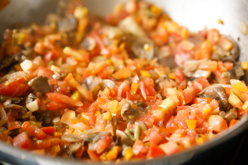 tomatoes mixed and being sautéed