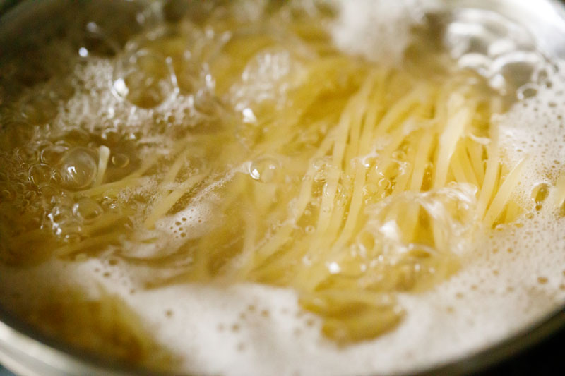 spaghetti being cooked in hot bubbling water