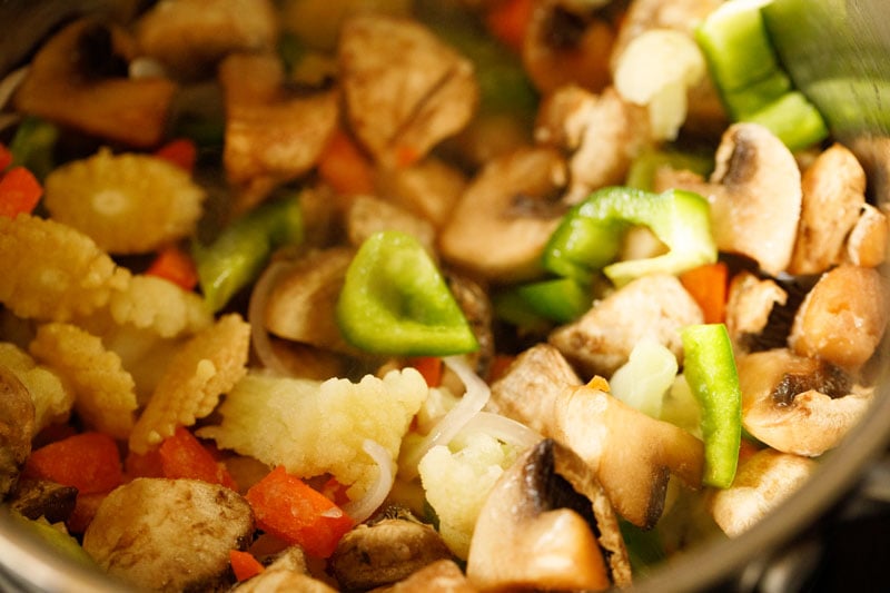 melange of vegetables added to skillet with sautéed mushrooms