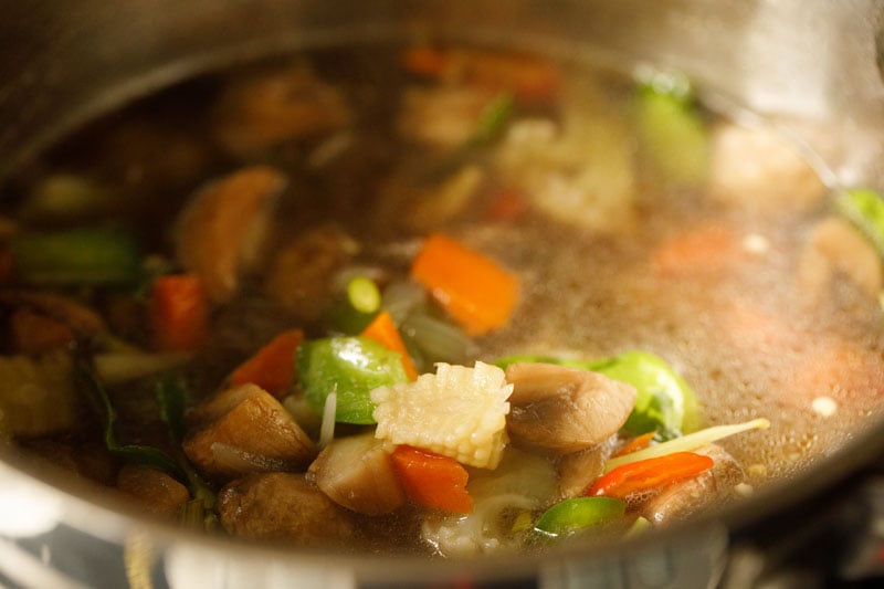 water added to veggies and spices for tom kha soup recipe