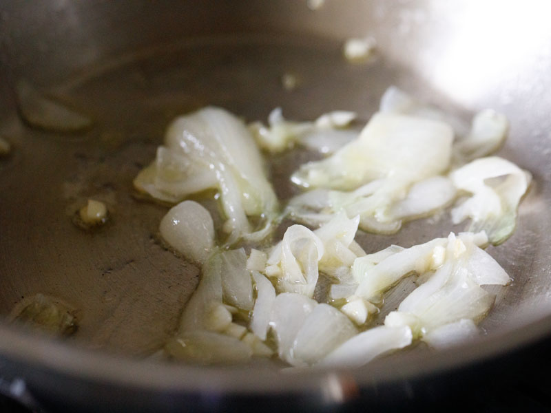 scallion whites and garlic sautéing in a skillet with oil